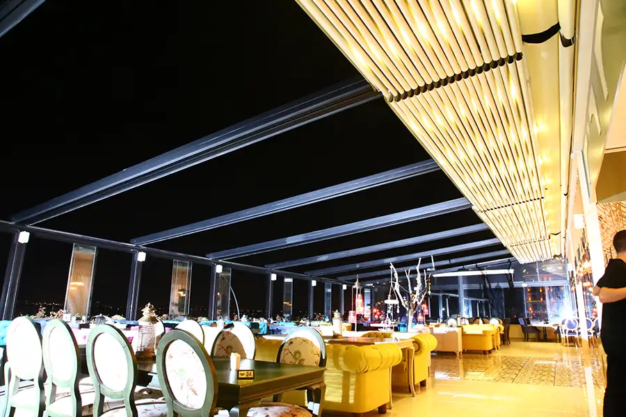 Cedrus Pergola System attached to commercial restaurant with retractable roof panels