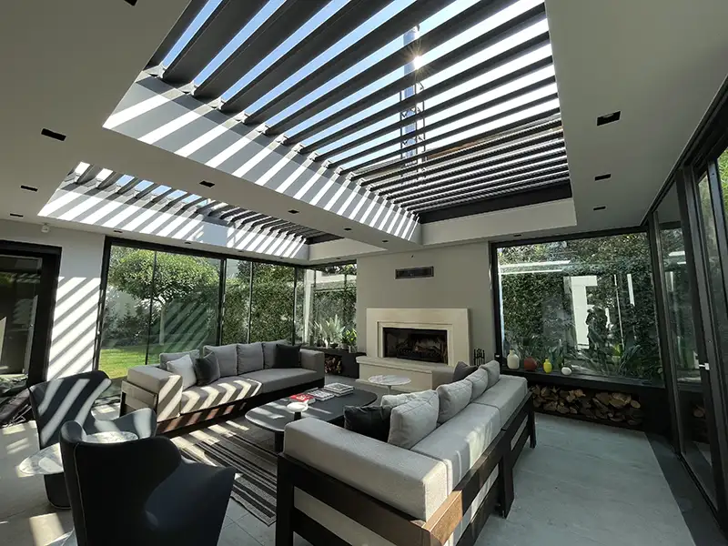 sunroom style pergola system with open roof panels letting the sun in